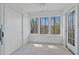 Sunroom with paneled walls, neutral carpet, three windows and access to the outside at 2209 N Forest Trl, Dunwoody, GA 30338