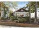 Charming home showcasing a well-maintained front yard with mature trees and professional landscaping at 573 Amsterdam Ne Ave, Atlanta, GA 30306