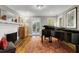 Elegant living room boasting hardwood floors, vintage travel posters, and a piano near a brick fireplace at 573 Amsterdam Ne Ave, Atlanta, GA 30306