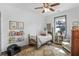 Cozy bedroom with plenty of natural light, featuring a ceiling fan, book shelves, and a sitting area at 91 Griggs Sw St, Marietta, GA 30064