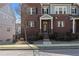 Attractive brick townhome showcasing a well-maintained lawn, black wrought iron fence, and inviting entrance at 2736 Bell Se Dr, Smyrna, GA 30080