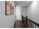 Hallway with dark hardwood flooring, three paintings, and a wooden railing at 2736 Bell Se Dr, Smyrna, GA 30080