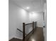 Hallway with wooden floors, black railings, white walls, and access to multiple rooms via white doors at 2736 Bell Se Dr, Smyrna, GA 30080
