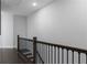 Upstairs hallway with dark hardwood flooring, wooden railing, and white walls at 2736 Bell Se Dr, Smyrna, GA 30080