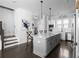 Well-lit kitchen with stainless steel appliances, white cabinets, gray island, and hardwood floors at 2736 Bell Se Dr, Smyrna, GA 30080