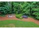 A secluded backyard retreat featuring a trampoline, fire pit, and lush green landscaping at 1135 Parkview Sw Way, Lilburn, GA 30047