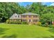 Traditional two-story brick home featuring a well-manicured lawn and mature landscaping at 1135 Parkview Sw Way, Lilburn, GA 30047