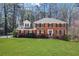 Charming two-story brick home with a manicured lawn, black shutters, and blossoming flower beds at 1135 Parkview Sw Way, Lilburn, GA 30047