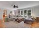 Spacious living room features a large sectional sofa, hardwood floors, and ample natural light from large windows at 1135 Parkview Sw Way, Lilburn, GA 30047