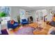 Cozy living room with hardwood floors, blue chairs, and large windows at 1135 Parkview Sw Way, Lilburn, GA 30047