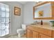 Bright powder room with granite countertop vanity, framed mirror, tiled floors and natural light from door at 1135 Parkview Sw Way, Lilburn, GA 30047