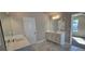 Bathroom with double sinks, white cabinetry, tile flooring, and large mirrors at 3718 Southfield Ct, Loganville, GA 30052