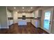 Modern kitchen featuring white cabinets, a gray backsplash, stainless steel appliances, and an island with quartz countertops at 3718 Southfield Ct, Loganville, GA 30052
