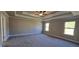 Spacious main bedroom featuring tray ceiling, neutral walls, carpeted floors, and three bright windows allowing ample sunlight at 3718 Southfield Ct, Loganville, GA 30052