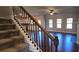 View of staircase featuring dark wood and iron spindles, carpeted steps, and an open view to the living room at 3718 Southfield Ct, Loganville, GA 30052