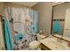 Cozy bathroom featuring floral shower curtain, patterned walls, and a modern vanity with a wooden accent at 525 Hilliard Ct, Suwanee, GA 30024