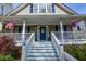 Welcoming front porch with stylish seating, colorful flower arrangements, and a beautifully decorated front door at 525 Hilliard Ct, Suwanee, GA 30024