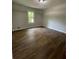 Bright bedroom with wood-look floors and natural light coming through the window at 1110 Toonigh Rd, Canton, GA 30115