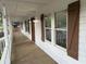 Long covered front porch featuring white railings, brown shutters, and updated lighting fixtures at 1110 Toonigh Rd, Canton, GA 30115
