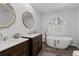 Bathroom featuring a soaking tub, a large window, double vanity sinks, and decorative mirrors at 116 Myrtle Rd, Woodstock, GA 30189