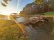 Waterfront view featuring a dock, boat, and sunset over a tranquil lake surrounded by trees at 116 Myrtle Rd, Woodstock, GA 30189