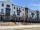 Townhomes boasting a mix of brick and white facade with black trim, complemented by gated front yards at 633 Silva St # 133, Cumming, GA 30040
