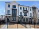Neat row of townhomes with black trim and a brick facade, each featuring a gated front yard and tidy landscaping at 633 Silva St # 133, Cumming, GA 30040