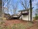 Back of home with a wooden deck, access stairs, and a serene, wooded backyard at 1336 Candlelite Ln, Snellville, GA 30078
