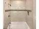 Clean bathtub with tiled surround and shower head, complemented by a mosaic tile accent strip at 1336 Candlelite Ln, Snellville, GA 30078