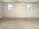 Spacious bedroom with neutral carpet, light walls, and two bright windows at 1336 Candlelite Ln, Snellville, GA 30078