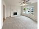 Inviting living room features a stone fireplace, large windows, and neutral carpeting at 1336 Candlelite Ln, Snellville, GA 30078