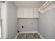 A small laundry room includes overhead cabinets and wood-look tile flooring at 1564 Pedro Sw Dr, Mableton, GA 30126