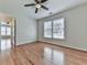Bright bedroom featuring gleaming hardwood floors, ceiling fan and a large window that provides ample natural light at 3891 Greensward Nw Vw, Kennesaw, GA 30144