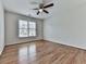 This bedroom features hardwood floors, neutral paint, a ceiling fan, and a window for a bright and airy feel at 3891 Greensward Nw Vw, Kennesaw, GA 30144