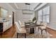 Dining room featuring modern chandelier, wainscoting, herringbone hardwood floors, and a marble topped table set for six at 3891 Greensward Nw Vw, Kennesaw, GA 30144