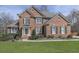 Charming brick two-story home featuring manicured lawn, mature shrubs, complemented by dark shutters and a classic front door at 3891 Greensward Nw Vw, Kennesaw, GA 30144