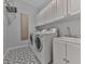 Functional laundry room with washer, dryer, white cabinets, sink, and tiled floors at 3891 Greensward Nw Vw, Kennesaw, GA 30144
