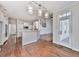 Open concept living space with hardwood floors, connecting to a modern kitchen and staircase at 3891 Greensward Nw Vw, Kennesaw, GA 30144