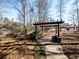 A scenic outdoor recreational area with a wooden pergola, brick pathway, and a charming playground set by a small creek at 3891 Greensward Nw Vw, Kennesaw, GA 30144