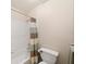Bright bathroom featuring a shower-tub combination with white tile and a striped curtain at 4370 Landover Way, Suwanee, GA 30024