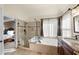 Bright bathroom featuring a soaking tub, glass enclosed shower, granite countertops, and tiled floors at 4370 Landover Way, Suwanee, GA 30024