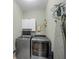 Well-lit laundry room featuring a washer, dryer, storage cabinet, ironing board and other laundry accessories at 4370 Landover Way, Suwanee, GA 30024
