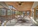Inviting screened porch with wood ceiling, ceiling fan, porch swing and comfortable seating with a view of wooded yard at 4370 Landover Way, Suwanee, GA 30024