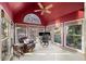 Bright sunroom with vaulted red ceiling, windows and comfortable chair and office setup at 4370 Landover Way, Suwanee, GA 30024