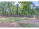 View of the fenced backyard featuring mature trees and a lush lawn at 105 Simonton (Tract 1) Se Rd, Lawrenceville, GA 30046