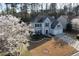 Aerial view of a two-story home with a manicured front lawn and two-car garage in a lush neighborhood at 10715 Glenbarr Dr, Johns Creek, GA 30097