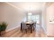 Bright dining room featuring hardwood floors, six chairs and an elegant chandelier with natural light shining through the windows at 10715 Glenbarr Dr, Johns Creek, GA 30097