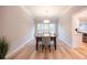 Bright dining room featuring hardwood floors, six chairs and an elegant chandelier with natural light shining through the windows at 10715 Glenbarr Dr, Johns Creek, GA 30097