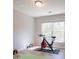 Exercise room featuring hardwood floors, a large window, an exercise bike and workout equipment at 10715 Glenbarr Dr, Johns Creek, GA 30097