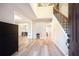 Bright foyer featuring hardwood floors, a staircase with decorative iron railings, and a view into the dining room at 10715 Glenbarr Dr, Johns Creek, GA 30097